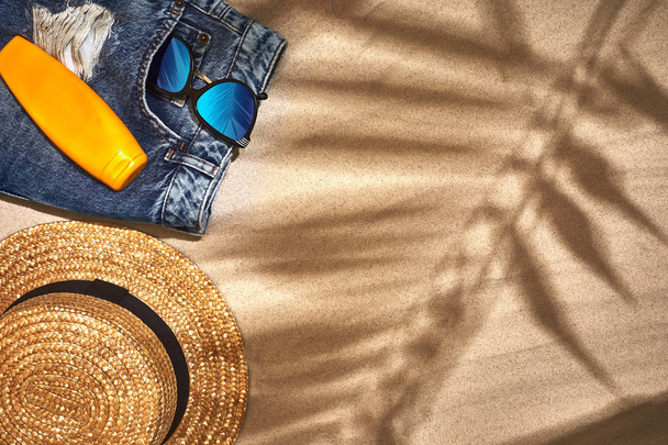 Zomer achtergrond met stro hoed, zonnebril, zonnebrandcrème fles en flip-flops - Foto, afbeelding
