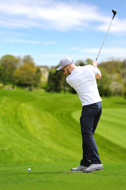 ゴルファーは、ゴルフボールを打つ - 写真・画像