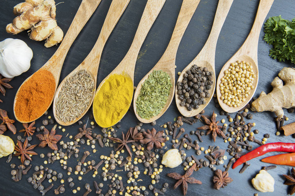 Variety spices with row of wooden spoon - 写真・画像