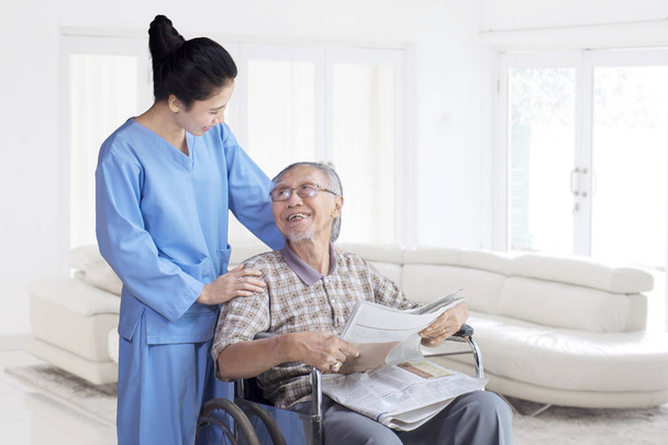 Viejo asiático hombre sonriendo a su enfermera
 - Foto, imagen