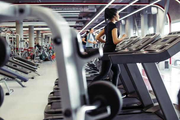Young fit woman running on treadmill - 写真・画像
