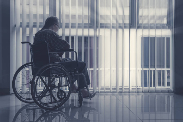Lonely elderly man sitting on wheelchair - Foto, imagen