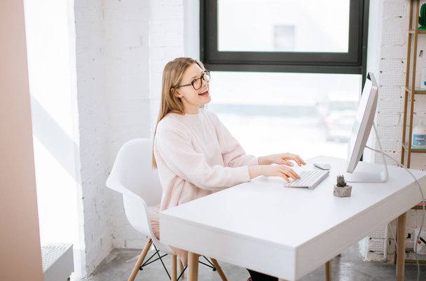businesswoman typing on keyboard in bright office - Фото, изображение