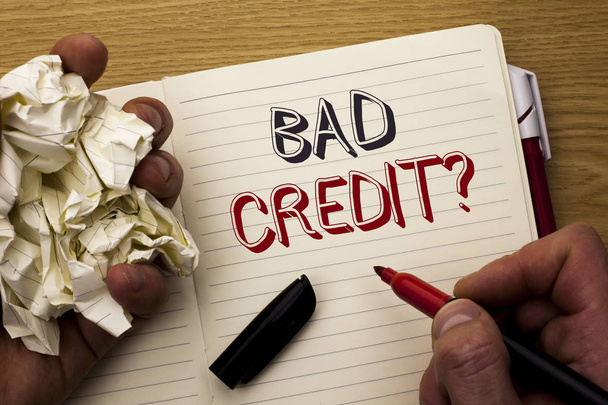Handwriting text Bad Credit Question. Concept meaning Low Credit Finance Economic Budget Asking Questionaire written by Man on Notebook Book Holding Marker on the wooden background Pen next to it. - Photo, Image
