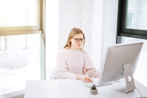 businesswoman typing on keyboard in bright office - Zdjęcie, obraz