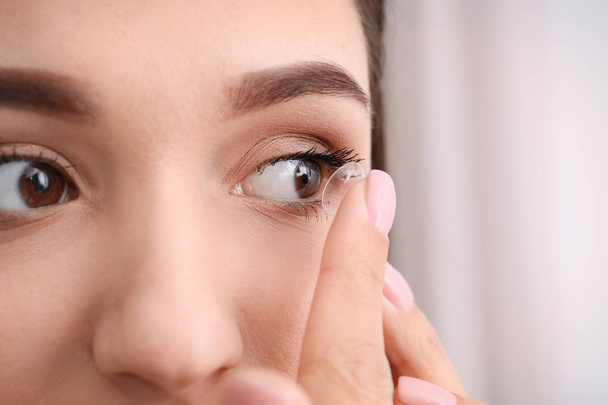 Young woman putting contact lens in her eye, closeup - Foto, Imagem