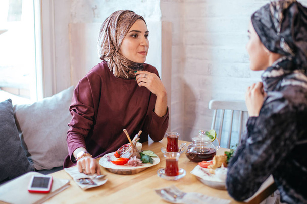 Two Muslim women in cafe, friends meeting - Fotoğraf, Görsel