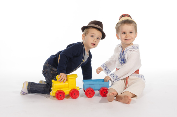 δύο παιδιά που έπαιζαν με ένα τρένο παιχνίδι - Φωτογραφία, εικόνα