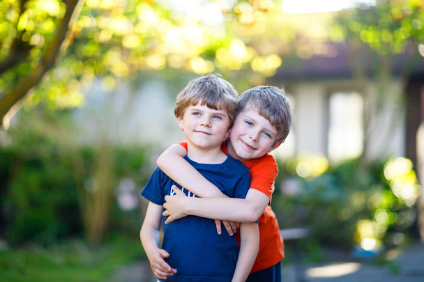 Dwa małe szkoły dla dzieci, chłopców, bliźniąt i rodzeństwa przytulanie na letni dzień - Zdjęcie, obraz