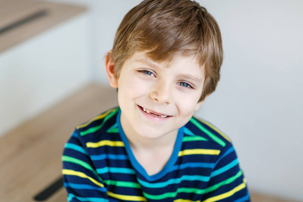 Portrait of little cute school kid boy in colorful clothes - 写真・画像