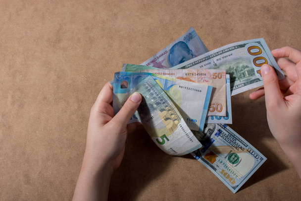 Χέρι που κρατά το αμερικανικό δολάριο που απομονώνονται σε φόντο ξύλινη - Φωτογραφία, εικόνα