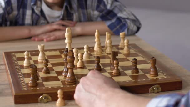 Father playing chess with little son at home, brain development activity closeup - Séquence, vidéo