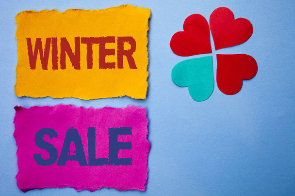Text sign showing Winter Sale. Conceptual photo Promotion Offer Shop Discount Season Offers Auction Deal Objective written on Tear Papers on the Blue background Hearts next to it. - Photo, Image