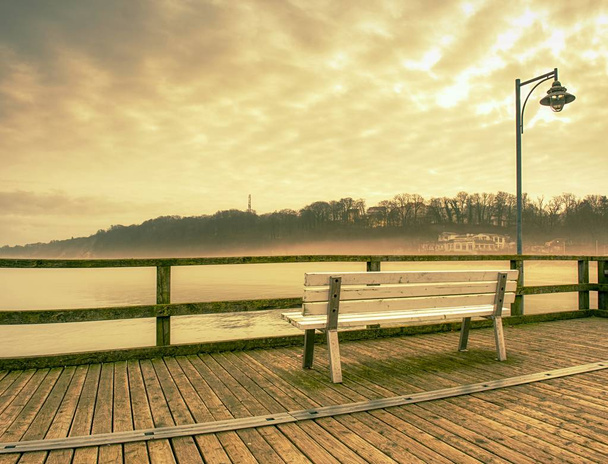 Muelle de madera en la mañana brumosa con postes de luz. Niebla pesada
  - Foto, imagen