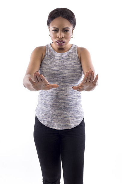 Black female wearing athletic outfit on a white background as a fitness trainer doing a stop gesture - Фото, изображение