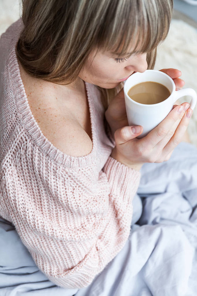 Schönheitsporträt entspannte Frau am Morgen und trinkt Kaffee im Bett. Kaukasische junge Frau entspannt im Bett mit Tasse Kaffee - Foto, Bild