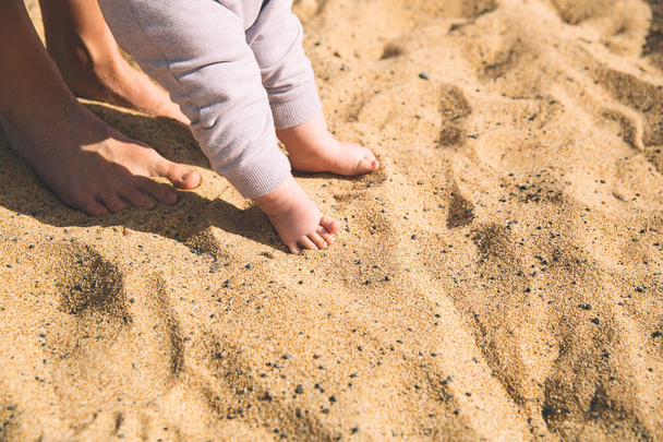 Mother and little baby feet on beach sand.  - Photo, image