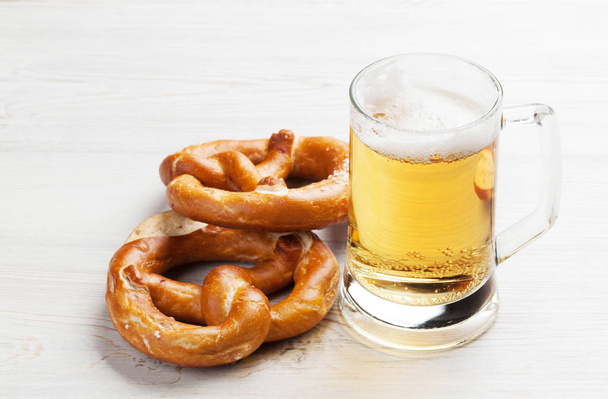 Cerveza y pretzels en mesa de madera
 - Foto, Imagen