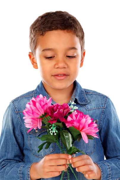 schattige gelukkig weinig Afrikaanse jongen in denim shirt met mooie boeket van roze bloemen geïsoleerd op witte achtergrond - Foto, afbeelding