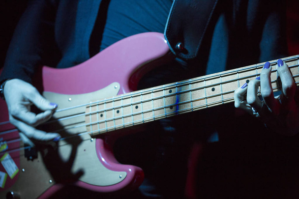 A kezében a nő elektromos basszusgitár - Fotó, kép