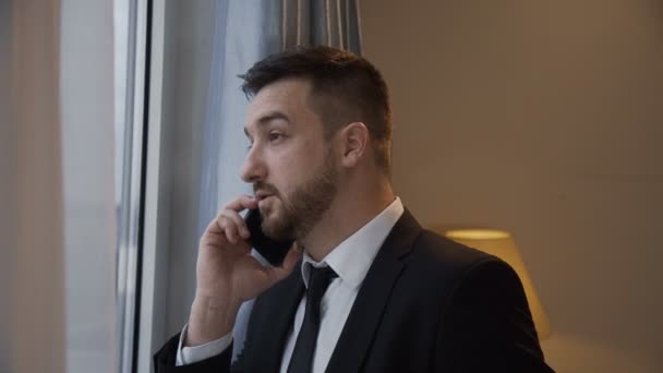 Confident businessman having phone call in hotel - Video