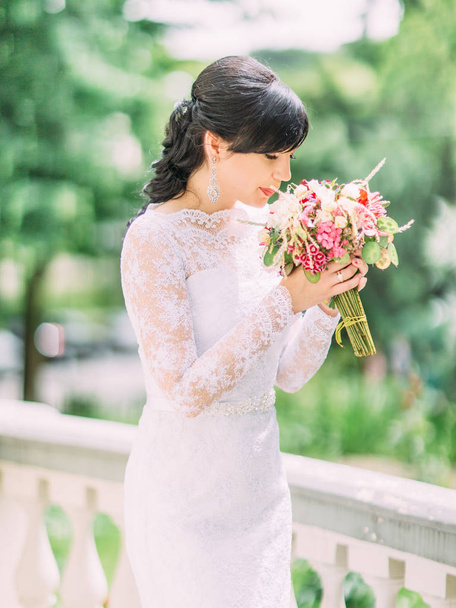 The side portrait of the beautiful bride smelling the wedding bouquet. - 写真・画像