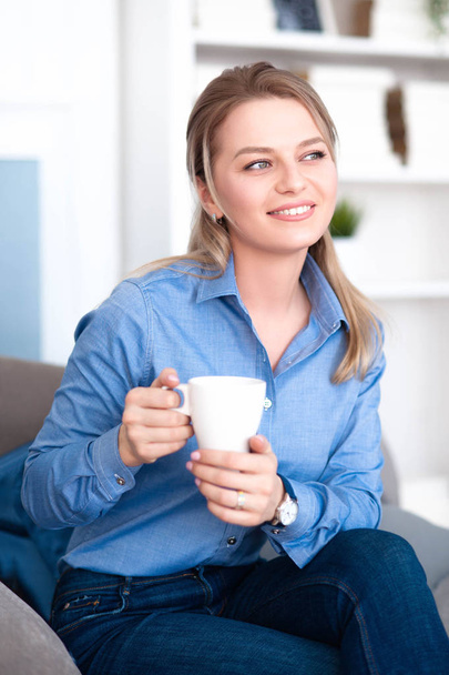 Girl with a beautiful smile drinking coffee - 写真・画像
