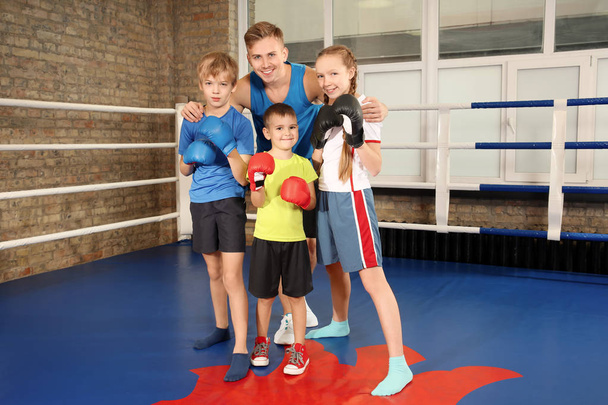 Little children with their trainer on boxing ring - Foto, Bild
