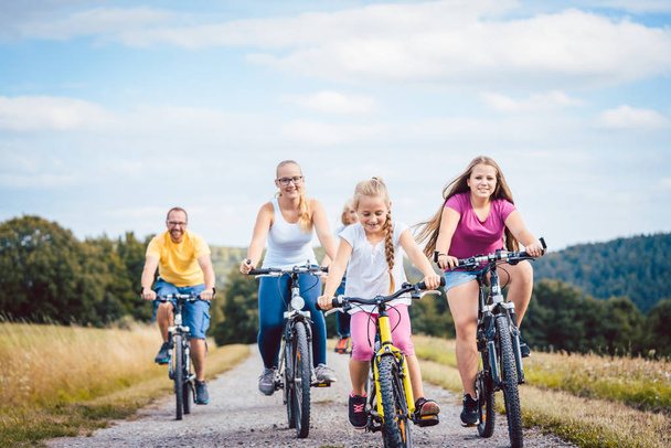 Сім'я катається на велосипедах після обіду в сільській місцевості
 - Фото, зображення