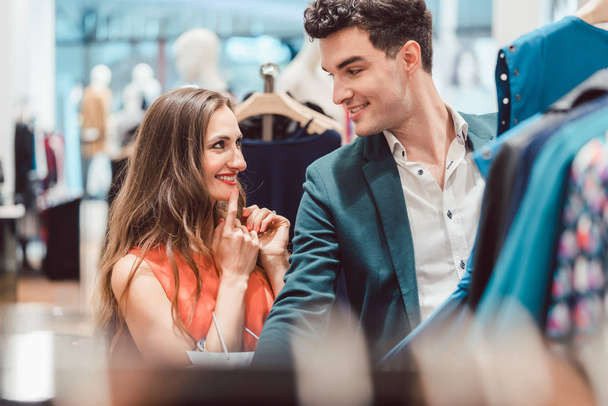 Женщина и мужчина обсуждают цвет платья в магазине моды
 - Фото, изображение