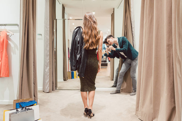 Homme faisant la photo de sa femme avec sa nouvelle robe dans le magasin de mode
 - Photo, image