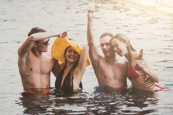 Skupina přátel, užívat si dovolenou v letním období. Mladí lidé, které baví tanec v bazénu - Fotografie, Obrázek