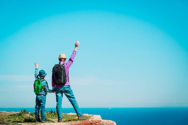 family travel - father and son hiking in mountains at sea - Photo, Image
