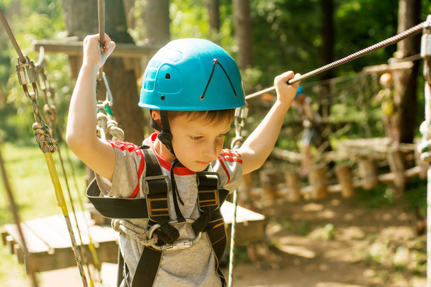 Cinque anni ragazzo su corda-way nella foresta
 - Foto, immagini