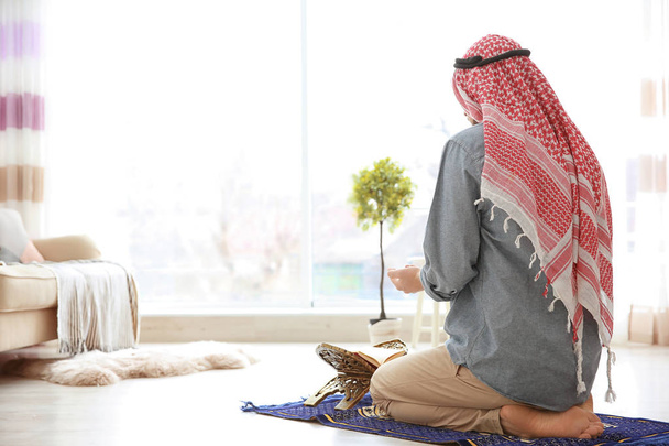 Muslim man praying on rug   - Foto, afbeelding
