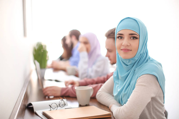 Muslim student with classmates in library - Fotoğraf, Görsel