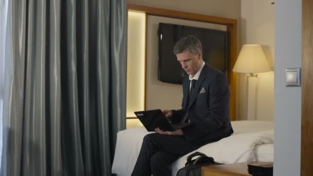 Liikemies poistuu hotellihuoneesta matkalaukun kanssa
 - Materiaali, video