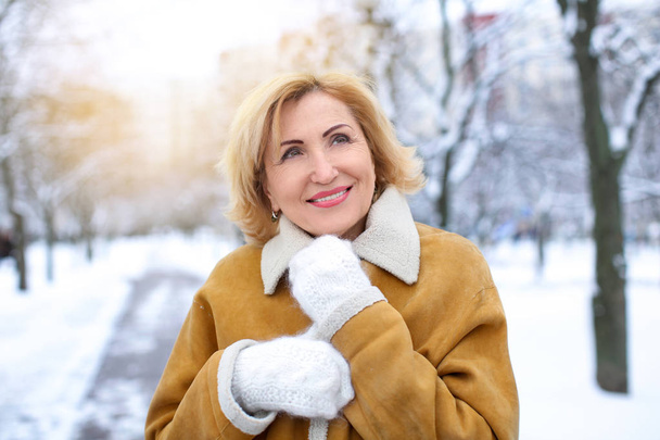 mature woman in snowy park - Фото, зображення