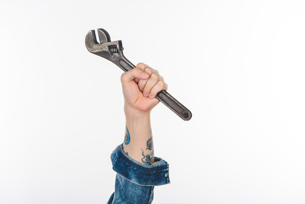 imagem cortada da mão masculina segurando chave ajustável isolada no branco
 - Foto, Imagem