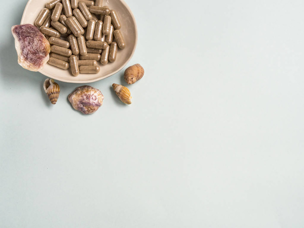 Pillole della capsula con conchiglie
 - Foto, immagini