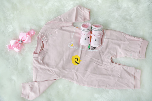 Collection items of bodysuits for newborn babies with socks on white fur background - Photo, image