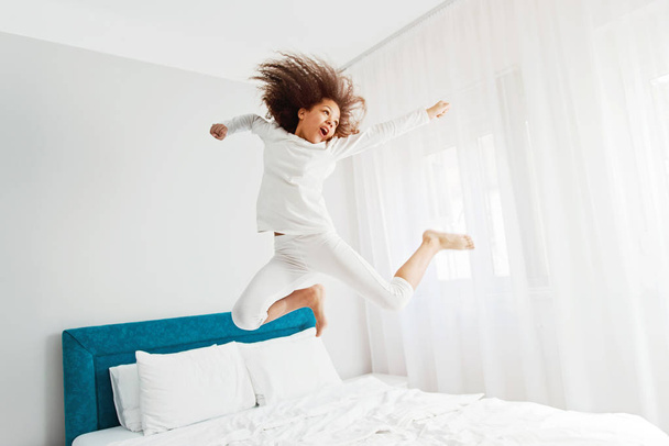 Cute girl jumping on the bed, happiness, joyful   - Фото, зображення