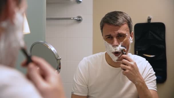 Adult man shaving in bathroom - Footage, Video