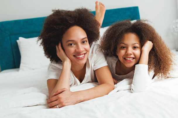 Mother and daughter enjoying on the bed, happy, smiling  - Photo, Image