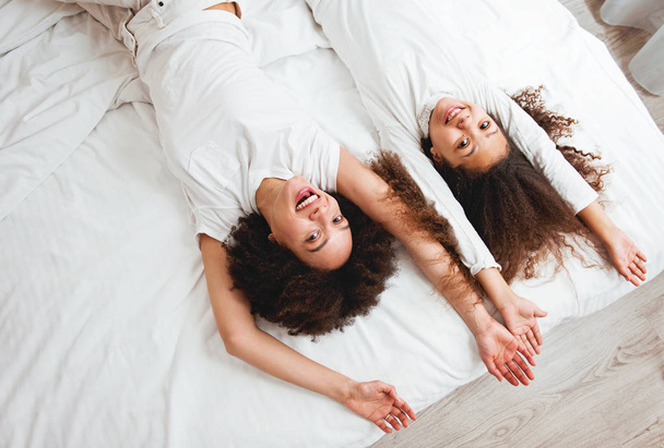 Mother and daughter enjoying on the bed, happy, smiling  - Valokuva, kuva