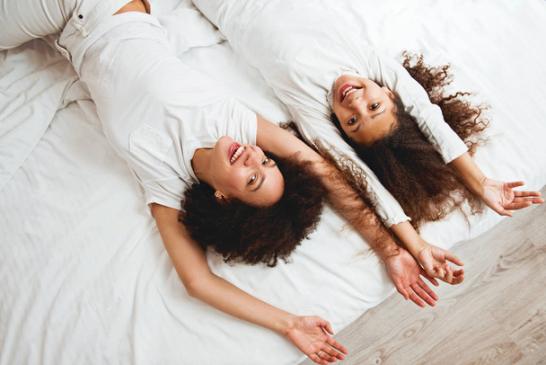 Mutter und Tochter genießen auf dem Bett, glücklich, lächelnd  - Foto, Bild