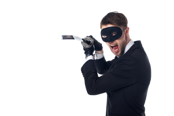 portrait of emotional spy agent in mask and gloves with katana isolated on white - Photo, Image