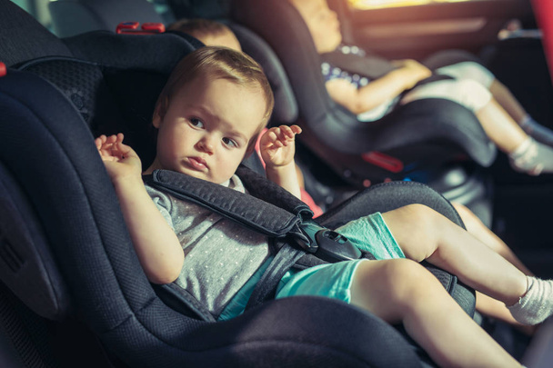 Trois enfants dans le siège de sécurité automobile - famille, transport, sécurité, voyage sur la route et concept de personnes
 - Photo, image