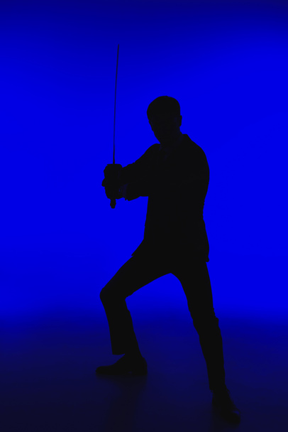 toned picture of silhouette of agent in suit with Katana - Photo, Image