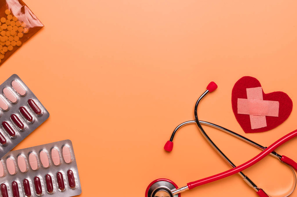 saúde e conceito médico estetoscópio vermelho e medicina no fundo laranja com espaço de cópia
 - Foto, Imagem